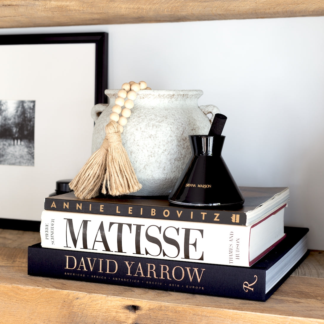 David Yarrow Photography-Americas Africa Antarctica Arctic Asia Europe - by David Yarrow, Foreword by Tom Brady, Published by Rizzoli-Black & Metallic Gold Side Spine Without Dust Jacket Angled Display on book shelf with Lennon Diffuser & Savina Vase