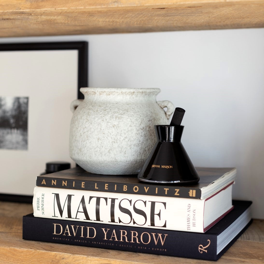 Sienna Maison Gold and Black Dyed Glass Encased in Crystal Glass Lennon Diffuser Set with Thick Reed Styled Display on Book Shelf with David Yarrow Photography Coffee Table Book and Savina Rustic Tuscan Vase