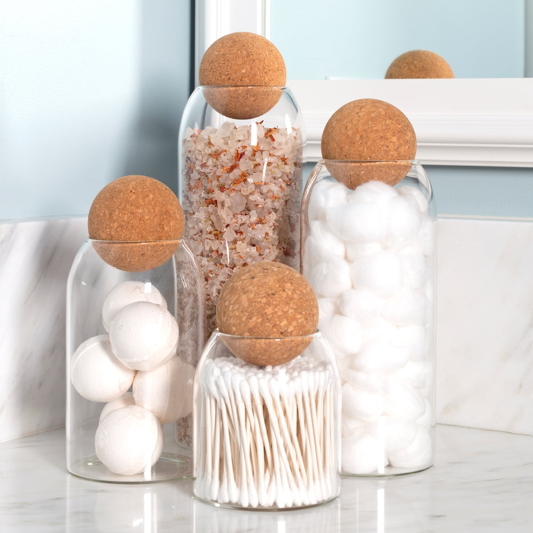 Sienna Maison Madison Cork Ball Dishwasher-Safe Borosilicate Glass Canisters Set of 4 sizes styled display on bathroom counter - organization of cotton balls, q-tips, bath salts, and bath bombs