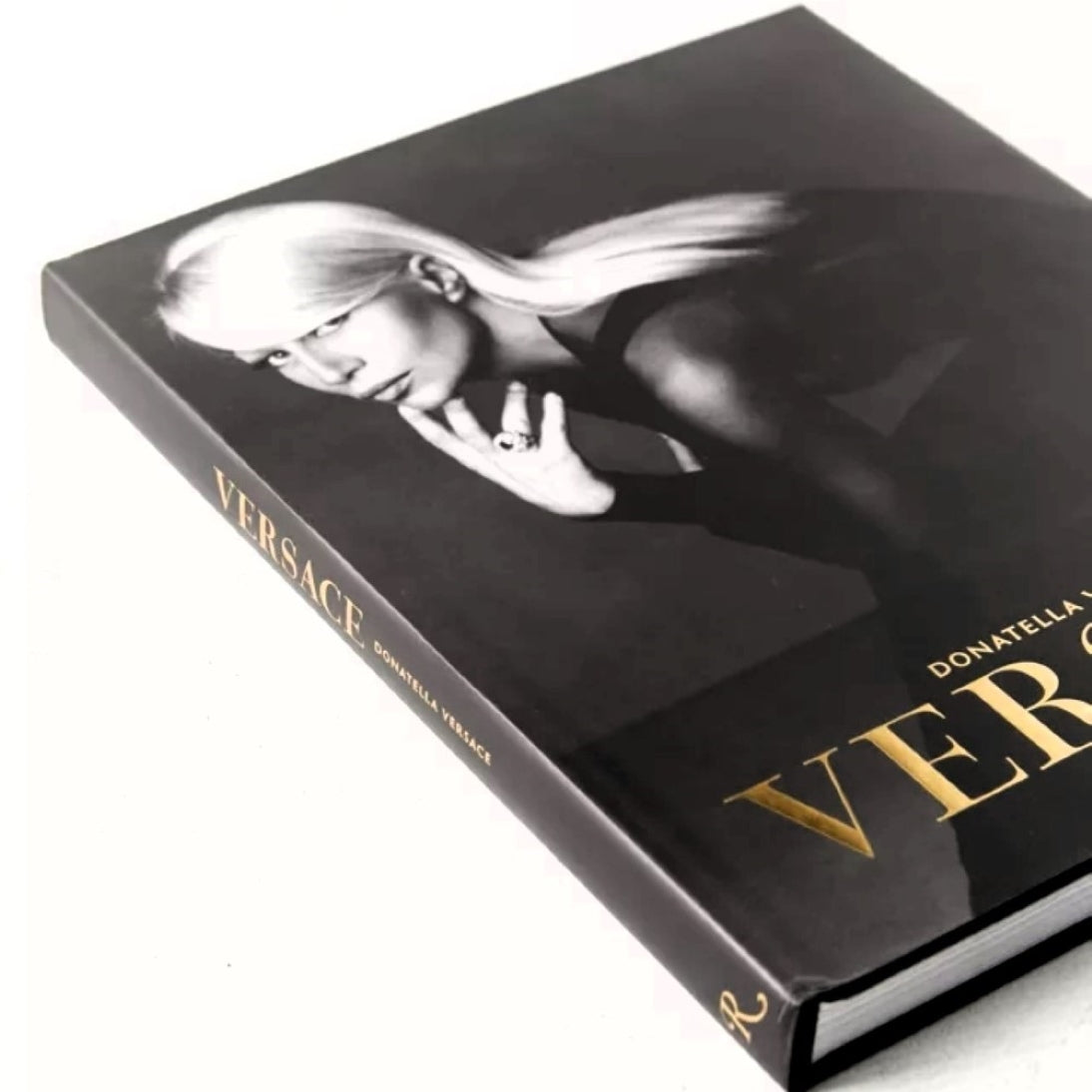 Versace by Donatella Versace, Maria Luisa Frisa, Stefano Tonchi, with contributions by Tim Blanks and Ingrid Sischy, published by Rizzoli - Black, White, and Metallic Gold Hardcover Coffee Table Book - Angled Front and Spine Photograph